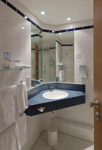 y baño con lavabo y espejo. en Holiday Inn Express Antwerpen City North, an IHG Hotel en Amberes