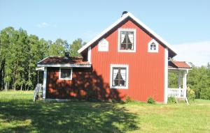 a red house in a field with a yard at Holiday Home Ljungkullen Ramkvilla in Ramkvilla