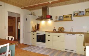 eine Küche mit einem weißen Kühlschrank und einem Tisch in der Unterkunft Amazing Home In Ystad With Kitchen in Ystad