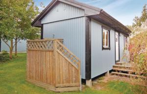 a small white building with a wooden gate at Beautiful Home In Gäsrsnäs With Wifi in Skräddaröd +7 photos