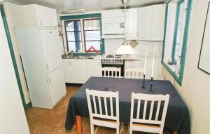 a kitchen with a table and chairs and a kitchen with white cabinets at Awesome Home In Mullsj With 2 Bedrooms in Mullsjö