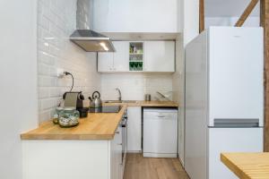 een keuken met witte apparatuur en een houten aanrecht bij The Color Hostel in Lissabon