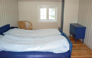 a bed in a bedroom with a blue dresser and a window at Haug Isakplassen in Heggje