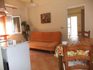 a living room with an orange couch and a table at Apartament Gjergji in Sarandë