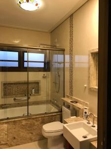 uma casa de banho com um chuveiro, um WC e um lavatório. em Casa Bela Vista em Guararema
