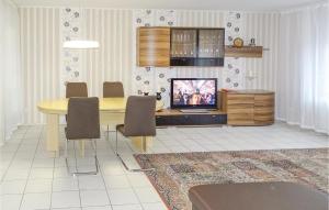 jadalnia ze stołem i telewizorem oraz stołem i krzesłami w obiekcie Beautiful Apartment In Lauenburg With Sauna w mieście Lauenburg/Elbe