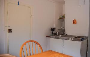 a kitchen with a table and a sink and a counter at One-Bedroom Holiday Home In Gullabo in Gullabo