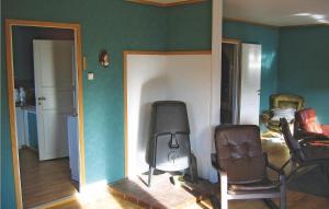 a living room with a chair and a television at Nice Home In Sirevåg With Kitchen in Sirevåg