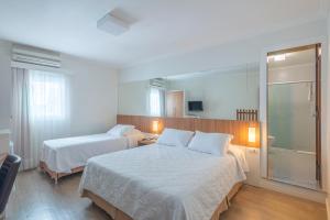 Postel nebo postele na pokoji v ubytování Hotel Glória Blumenau
