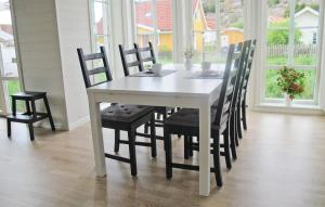 a white dining room table and chairs in a room with windows at Lovely Home In Hamburgsund With Wifi in Hamburgsund