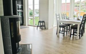a dining room with a fireplace and a table and chairs at Lovely Home In Hamburgsund With Wifi in Hamburgsund +21 photos