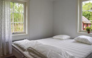 a bedroom with a bed with two pillows and a window at One-Bedroom Holiday Home In Gullabo in Gullabo
