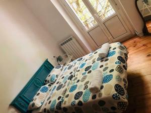 a bed with a comforter in a room with a window at ordizia piso con vistas al parque in Villafranca de Ordizia