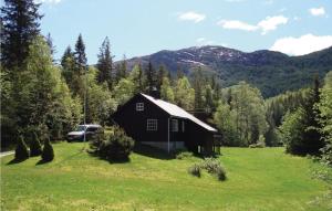 a black barn in the middle of a green field at 3 Bedroom Stunning Home In Tonstad in Bjørnestad