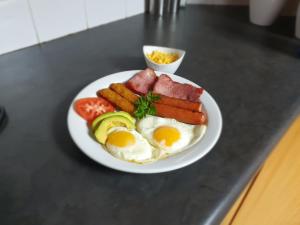 ein Frühstücksteller mit Eiern, Wurst und Gemüse in der Unterkunft Leach Lodge in Kuruman