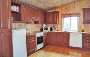 eine Küche mit Holzschränken und weißen Geräten in der Unterkunft Sjusjøen Pihl 185 in Sjusjøen