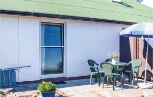 un patio con tavolo, sedie e ombrellone di Two-Bedroom Holiday Home In Usedom a Wilhelmshof