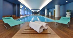 a swimming pool with two chairs and a table at Best Western Plus Hotel Le Favaglie in Cornaredo