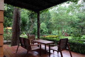 un tavolo e sedie in legno su una terrazza di legno di Moosiyard Hometel Khaoyai a Mu Si