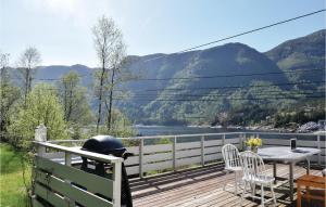 a deck with a table and chairs and a grill at Gorgeous Home In Eivindvik With Kitchen in Eivindvik