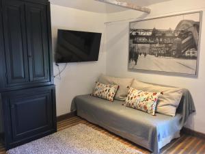 ein Wohnzimmer mit einem Sofa und einem TV an der Wand in der Unterkunft Haus Honigstal Landhaus Café in Wuppertal
