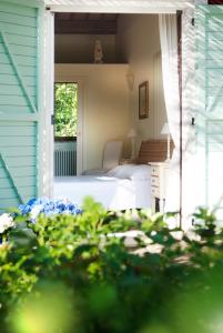 a bedroom with a bed and a window on a house at Borgo Rosso Country House B&B in Sirolo