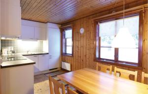 a kitchen with a wooden table and a large window at 2 Bedroom Awesome Home In Sysslebäck in Sysslebäck +6 photos