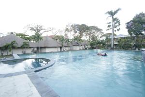 a person swimming in a pool at a resort at Alit Beach Resort and Villas in Sanur