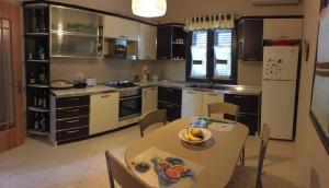 eine Küche mit einem Tisch und einem weißen Kühlschrank in der Unterkunft Ajmi Luxury Villa in Golem