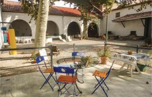 a patio with chairs and a table in a courtyard at Nice Home In Narbonne With Sauna in Narbonne +20 photos