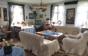a living room with couches and a table and chairs at Stunning Home In Blidsberg With 2 Bedrooms in Älmestad