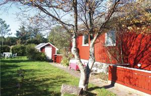 una casa roja con una valla roja y un árbol en 5 Bedroom Awesome Home In Borhaug en Borhaug