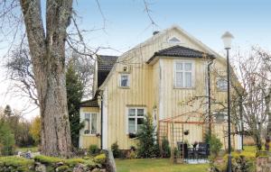 a yellow house with a tree in front of it at Stunning Home In Blidsberg With 2 Bedrooms in Älmestad