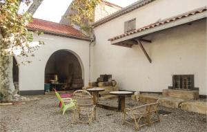 a patio with chairs and tables in front of a building at Nice Home In Narbonne With Sauna in Narbonne