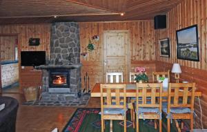 Cozy Home In Oskarstrm With Kitchen في Karlstorp: غرفة طعام مع طاولة ومدفأة