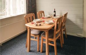 una mesa de madera con sillas y una botella de vino en Nice Apartment In Hippolytushoef With 2 Bedrooms And Wifi, en Hippolytushoef