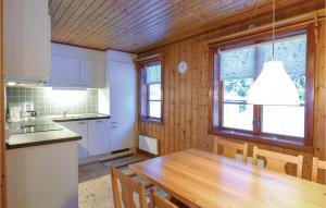 Awesome Home In Sysslebck With Wifi في Sysslebäck: مطبخ مع طاولة خشبية وسقف خشبي