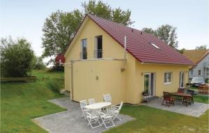 a yellow house with a table and chairs at Two-Bedroom Apartment In Boiensdorf in Boiensdorf