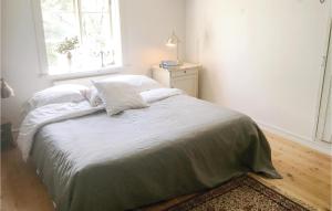 a white bedroom with a bed with a window at Stunning Home In Nykping With 2 Bedrooms, Sauna And Wifi in Ånsund