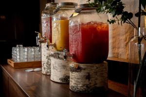 a row of jars filled with drinks on a table at Hotel Gyllene Uttern in Gränna