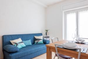 a blue couch in a living room with a table at Sun in Nago-Torbole