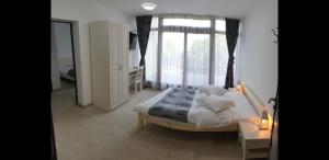 a bedroom with a bed and a large window at Casuta Din Padure in Drăguş