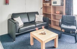 a living room with a black leather couch and a coffee table at Nice Apartment In Hippolytushoef in Hippolytushoef