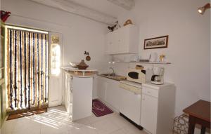 a kitchen with white cabinets and a window and a sink at Gorgeous Home In Crillon Le Brave With Wifi in Crillon-le-Brave