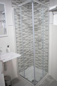 a shower with a glass door in a bathroom at Hostal Goyesco Plaza in Plasencia