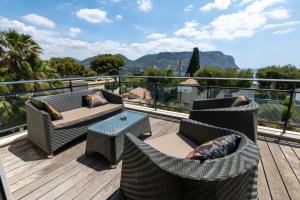 a balcony with chairs and a table on a deck at Villa Cassis in Cassis
