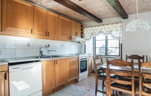 a kitchen with wooden cabinets and a table and a dining room at Awesome Apartment In Havdhem With 3 Bedrooms And Wifi in Havdhem