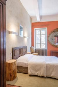a bedroom with a bed and a chair and a window at Hôtel Restaurant d'Alibert in Caunes-Minervois