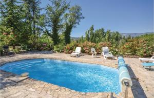 a swimming pool with two chairs and a table at Gorgeous Home In Crillon Le Brave With Wifi in Crillon-le-Brave