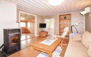 a living room with a table and a fireplace at Beautiful Home In Klssbol With 2 Bedrooms And Wifi in Prästhög